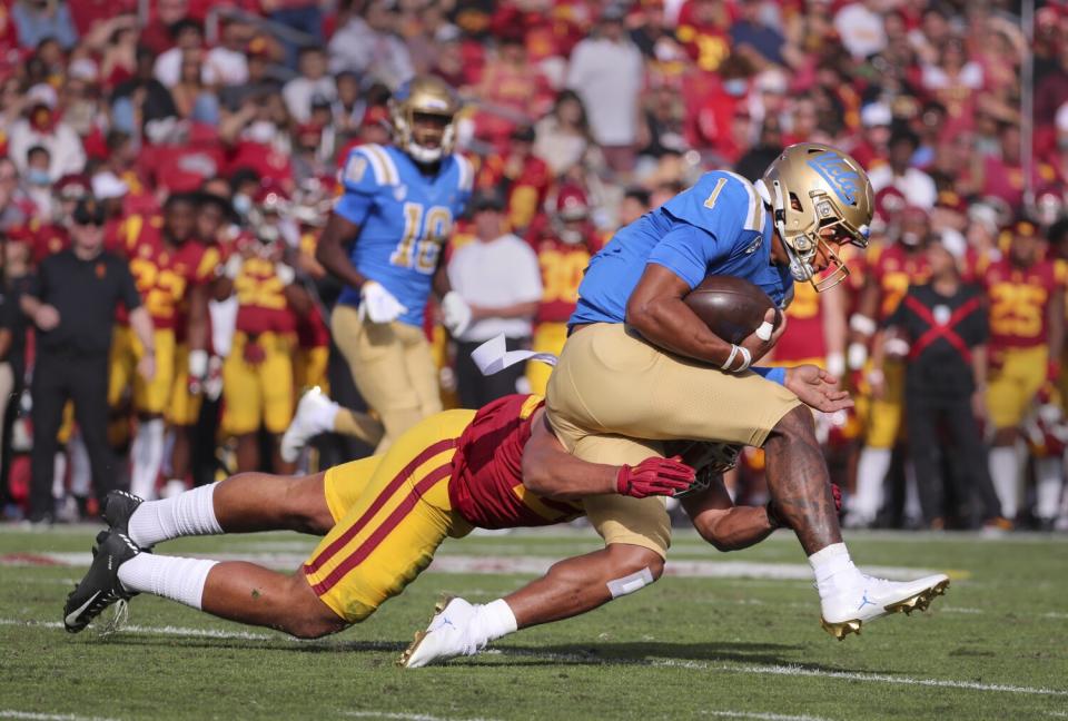 UCLA quarterback Dorian Thompson-Robinson is tackled by a USC defender.