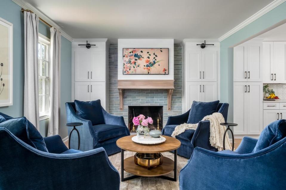 A quartet of armchairs in front of the fireplace creates a warm places for conversation