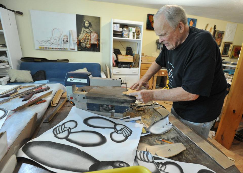 J. Dixon Bergman uses a saw to cut wood that will be used in his artwork in his Plymouth studio.