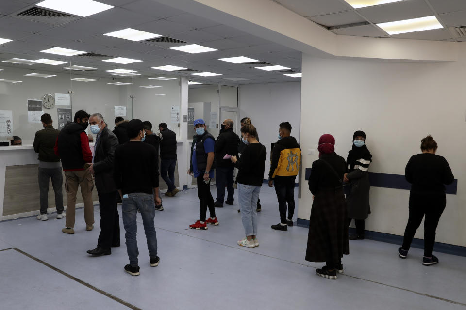 People stand in line for a coronavirus test at a testing center in the Rafik Hariri University Hospital in Beirut, Lebanon, Monday, Jan. 11, 2021. Lebanon's caretaker prime minister said Monday the country has entered a "very critical zone" in the battle against coronavirus as his government mulls tightening nationwide lockdown announced last week. (AP Photo/Bilal Hussein)