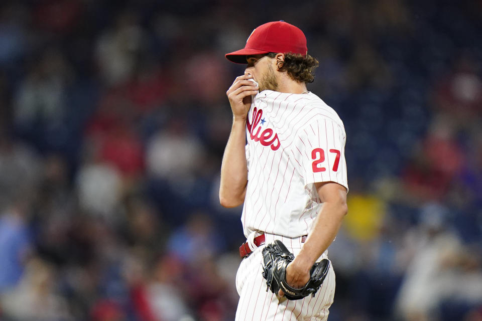 Philadelphia Phillies pitcher Aaron Nola wipes his face after giving up a two-run single to Boston Red Sox's Xander Bogaerts during the fifth inning of an interleague baseball game, Friday, May 21, 2021, in Philadelphia. (AP Photo/Matt Slocum)