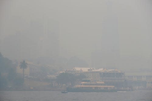 A ferry sails on the harbor as thick smoke settles in Sydney, Australia, Tuesday, Dec. 10, 2019. Hot dry conditions have brought an early start to the fire season.