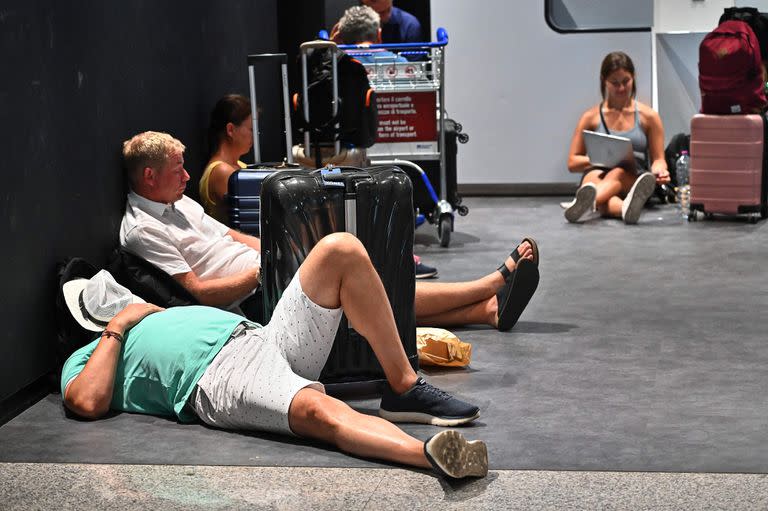 Pasajeros esperan en el aeropuerto Fiumicino de Roma durante una huelga de trabajadores de algunas compañías aéreas que cancelaron por la fuerza unos 400 vuelos, en Roma, el 17 de julio de 2022.