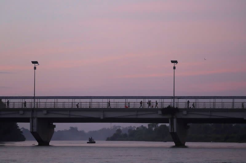 People cross the border bridge between Guatemala and Mexico as seen from Tecun Uman