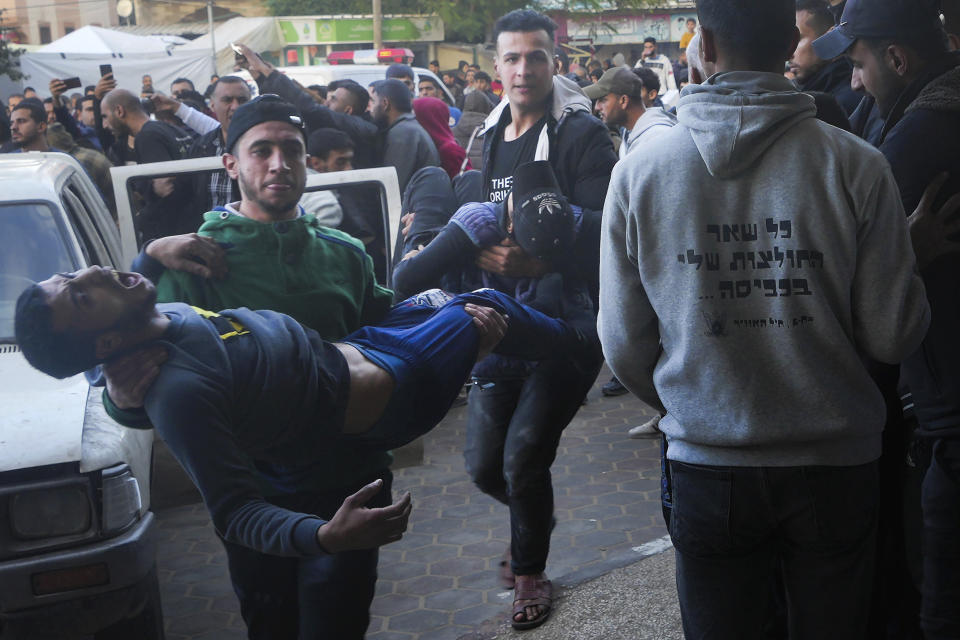 Palestinians wounded in the Israeli bombardment of the Gaza Strip are brought to the hospital in Deir al Balah, Gaza Strip, on Sunday, Dec. 24, 2023. (AP Photo/Adel Hana)