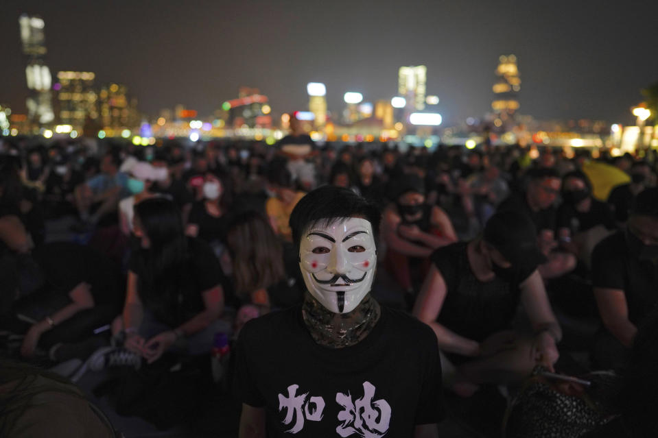 A protestor wearing a mask joins others at Tamar Park in Hong Kong, Saturday, Sept. 28, 2019. Thousands of people gathered Saturday for a rally in downtown Hong Kong, belting out songs, speeches and slogans to mark the fifth anniversary of the start of the 2014 Umbrella protest movement that called for democratic reforms in the semiautonomous Chinese territory. (AP Photo/Vincent Yu)