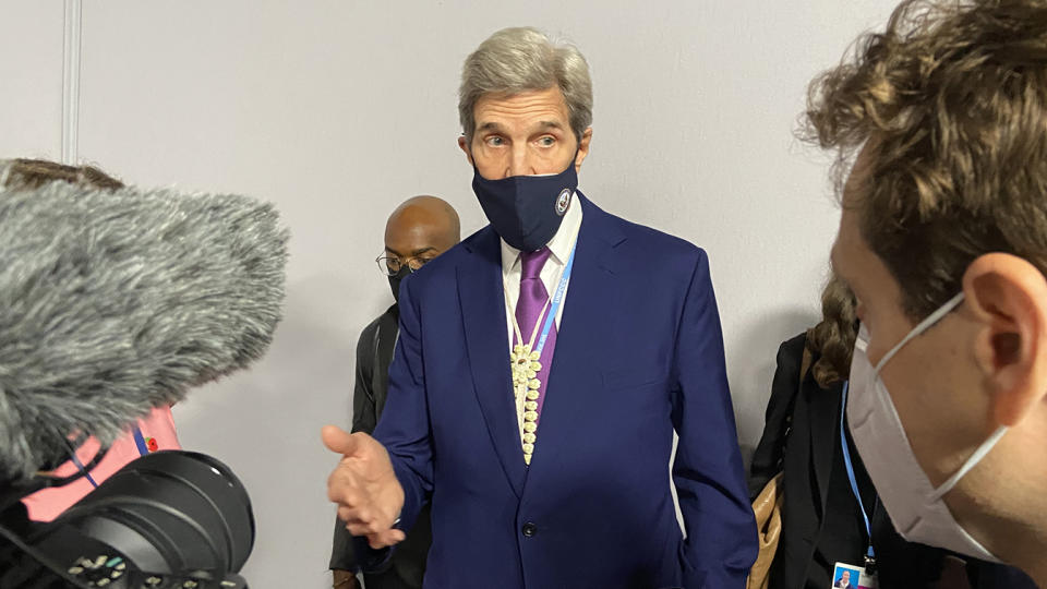 U.S. climate adviser John Kerry speaks to the media in the hallway at COP26 in Glasgow, Scotland, on Monday.