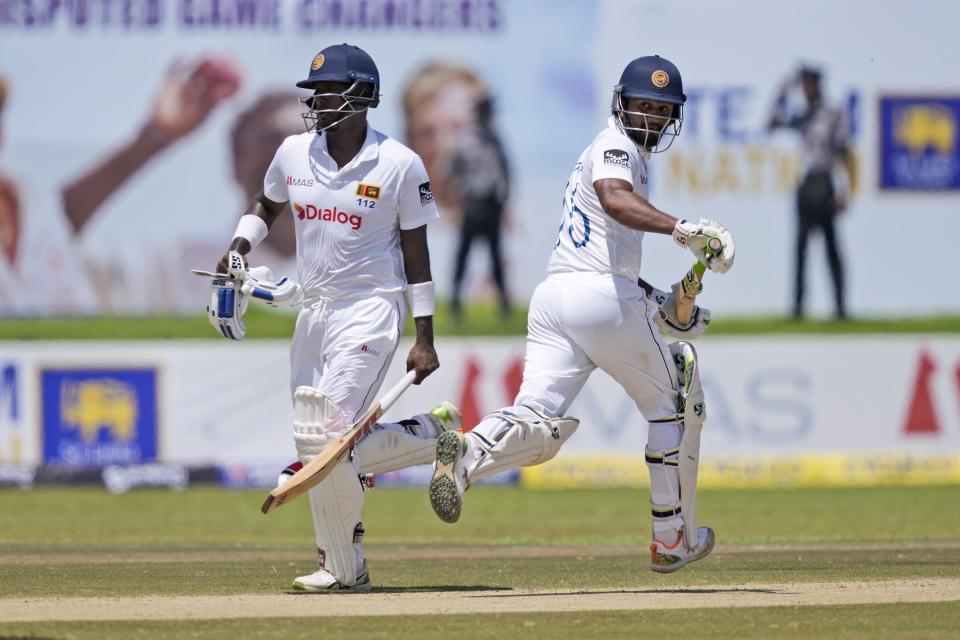 Sri Lanka's Dimuth Karunaratne, right, and Angelo Mathews run between wickets during the day one of their first test cricket match with Australia in Galle, Sri Lanka, Wednesday, June 29, 2022. (AP Photo/Eranga Jayawardena)