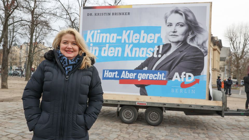 Kristin Brinker, from the far-right AfD, in front of an election poster reading "Climate-gluers go to jail!" at Charlottenburg Palace in Berlin on January 21, 2023. - Jörg Carstensen/picture alliance/Getty Images