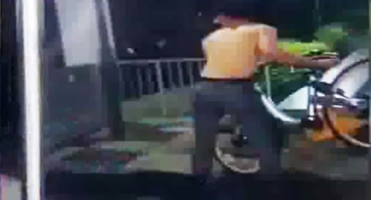 Video screengrab showing a man throwing a shared bike into a canal.