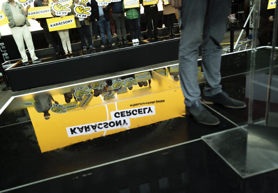 A campaign banner is seen reflected behind Budapest mayor Gergely Karacsony, one of the frontrunners in a race to unseat Hungary's Prime Minister Viktor Orban, while holding a campaign event in Budapestt, Hungary on Sept. 17, 2021. The rally marked the start of a primary election that will choose a joint opposition candidate to face off with Hungary's hardline leader in polls next year. (AP Photo/Bela Szandelszky)