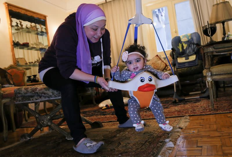 Yasmina al-Habbal, plays with Ghlaya, an orphan she sponsors, at her home in Cairo