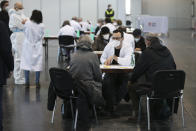 Two Holocaust survivors get information prior to their vaccination with the Pfizer/BioNTech vaccine against the COVID-19 disease, at a vaccination center on International Holocaust Remembrance Day in Vienna, Austria, Wednesday, Jan. 27, 2021. Hundreds of Holocaust survivors in Austria and Slovakia were poised to get their first coronavirus vaccinations on Wednesday to acknowledge their past suffering with a special tribute 76 years after the liberation of the Auschwitz death camp, where the Nazis killed more than 1 million Jews and others. The vaccinations were also offered to all other Jews in the area older than 85. (AP Photo/Ronald Zak)