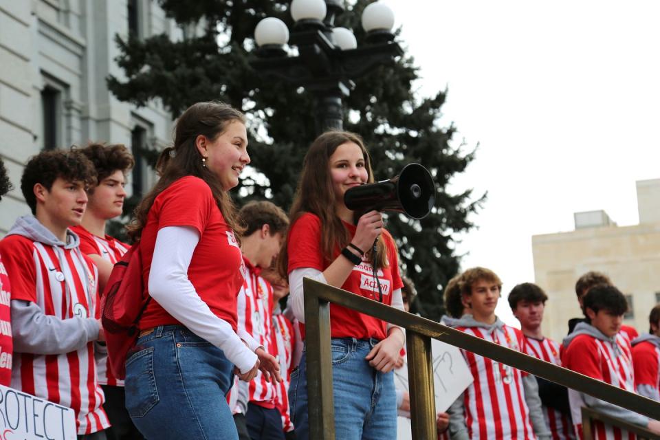 a person holding a camera and a group of people standing around