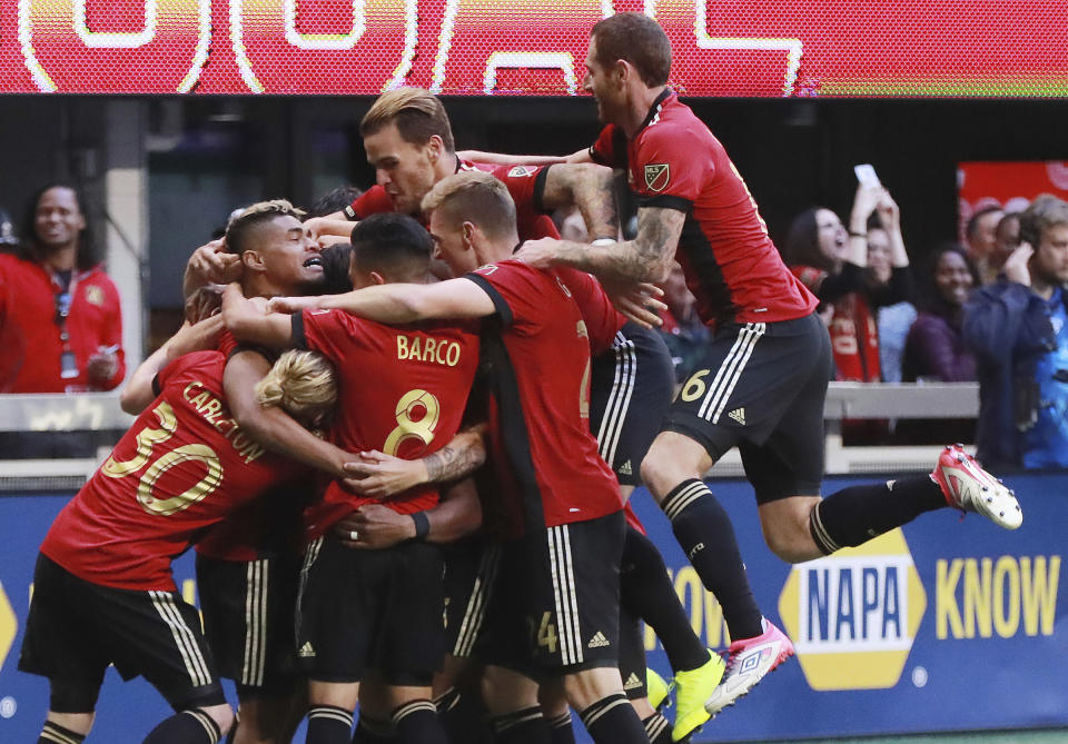 Atlanta United players mob Franco Escobar after his goal for a 1-0 lead over the Chicago Fire during the first half in a MLS soccer match on Sunday, Oct 21, 2018, in Atlanta. (Curtis Compton/Atlanta Journal-Constitution via AP)