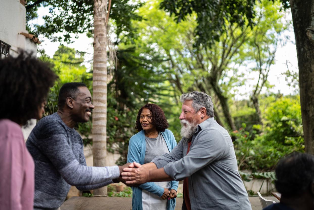 Neighbors greeting each other at front house