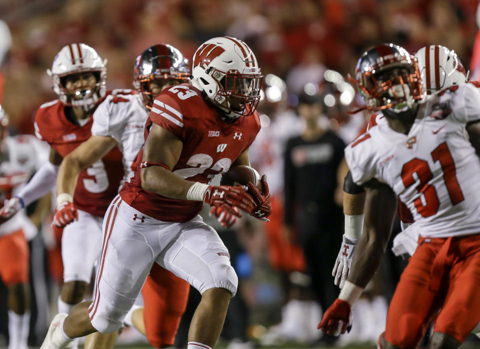 Wisconsin running back Jonathan Taylor (23) dashes past Western Kentucky defensive back Antwon Kincade (31) on the way to a 47-yard touchdown during the first half of an NCAA college football game Friday, Aug. 31, 2018, in Madison, Wis. (AP Photo/Andy Manis)