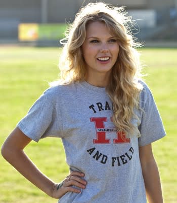 Taylor Swift in a gray T-shirt on a football field