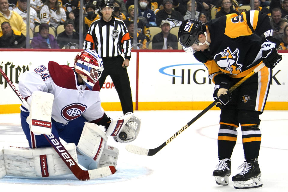 Montreal Canadiens goaltender Jake Allen (34) gloves a shot with Pittsburgh Penguins' Evan Rodrigues (9) looking for a rebound during the second period of an NHL hockey game in Pittsburgh, Saturday, Nov. 27, 2021. (AP Photo/Gene J. Puskar)