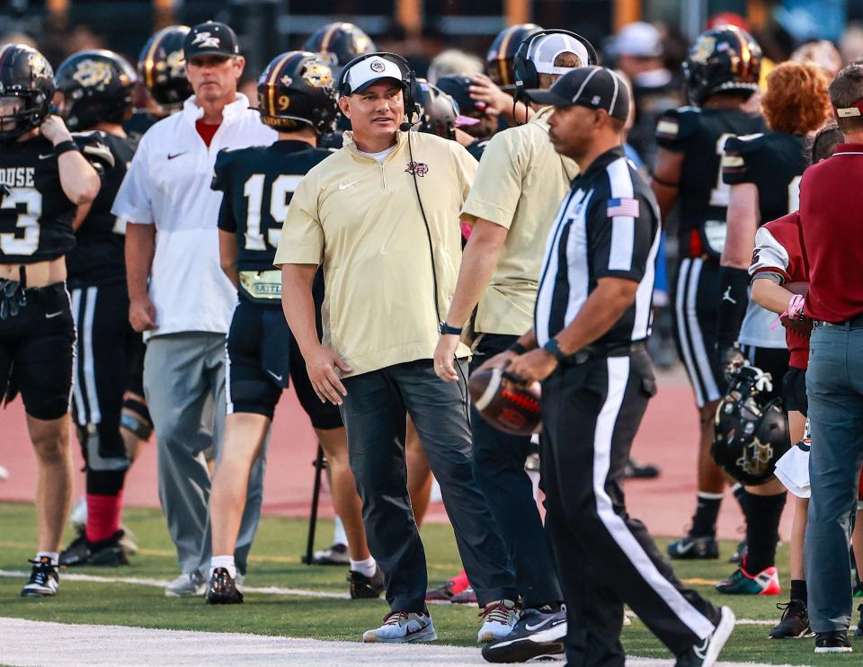 Rouse coach Joshua Mann (center) has led his team to first place (for now) in District 11-5A. The Raiders are 6-1 overall, 3-0 in district.