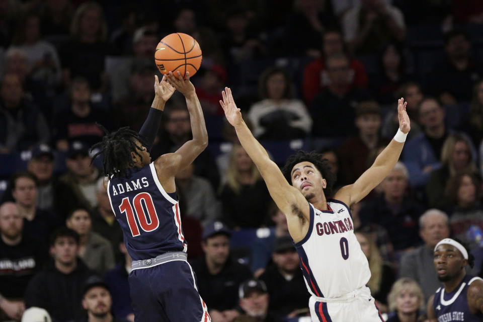 Jackson State guard Chase Adams (10) shoots while pressured by Gonzaga guard Ryan Nembhard (0) during the first half of an NCAA college basketball game, Wednesday, Dec. 20, 2023, in Spokane, Wash. (AP Photo/Young Kwak)
