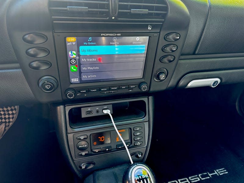 The interior of a 2003 Porsche 911 with Apple CarPlay on the stereo.