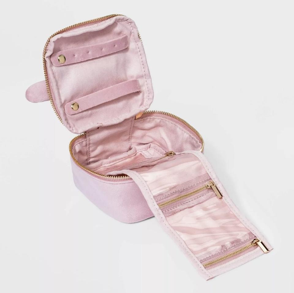 Pink velvet jewelry organizer opened up with multiple pocket inserts