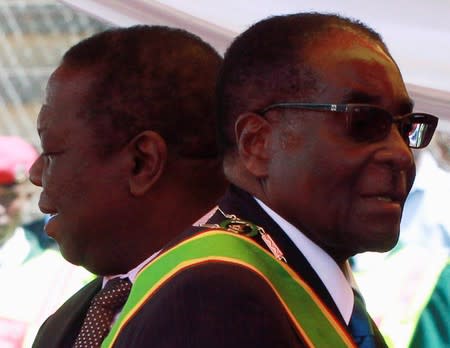 FILE PHOTO: Zimbabwean President Robert Mugabe and Prime Minister Morgan Tsvangirai arrive at a rally marking Zimbabwe's 31st independence anniversary celebrations in Harare