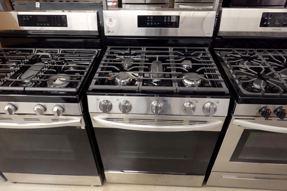 Three gas-burning stoves for sale at a home improvement store.