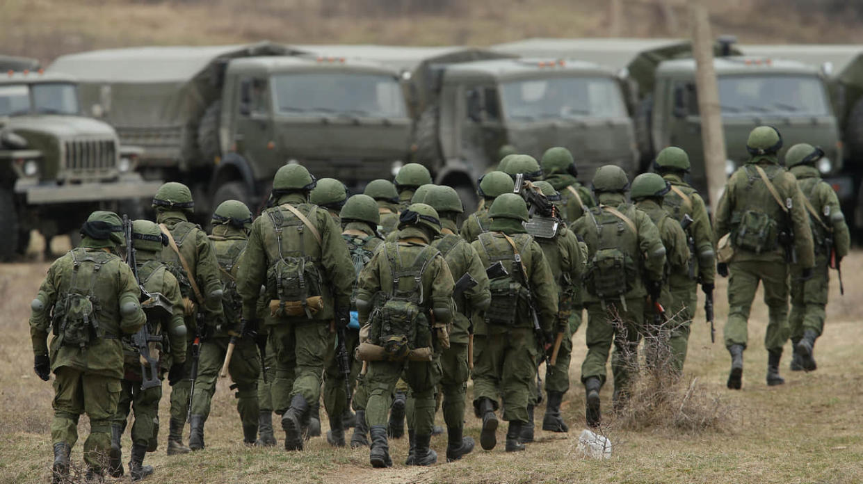 Soldiers who took up positions around a Ukrainian military base walk towards their parked vehicles in Crimea on March 2, 2014 in Perevalne, Ukraine. Stock photo: Getty Images