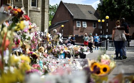 Flowers, tributes and messages are left for the victims of the fire at the Grenfell apartment tower in North Kensington, London, Britain, June 23, 2017. REUTERS/Hannah McKay