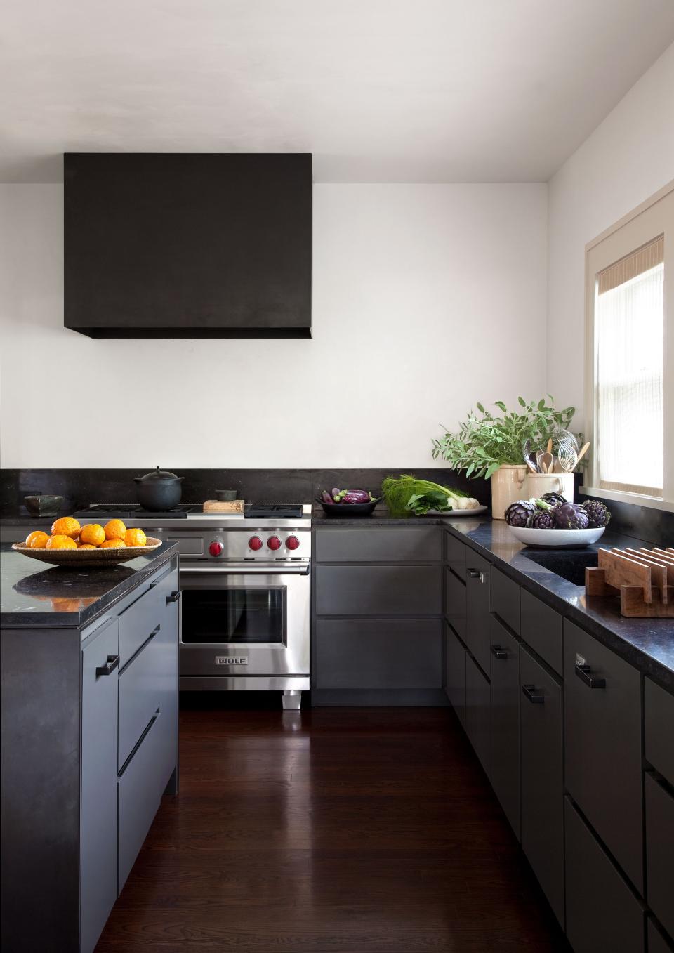 In keeping with Tedhams’s reliance on a limited palette, the kitchen cabinets are painted the same color as the exterior of the house. Countertops are Belgian bluestone. Range by Wolf; dishwasher by Fisher & Paykel.