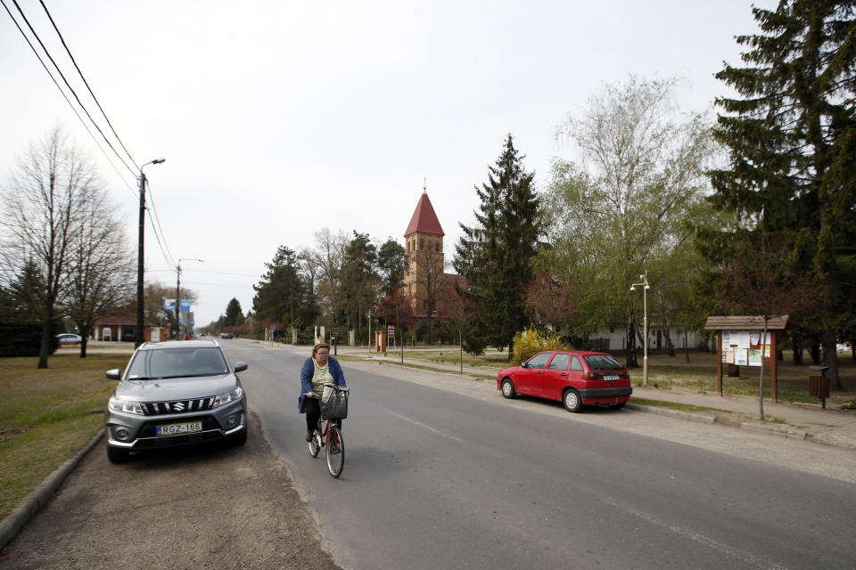 In this photo taken Monday, April 8, 2019, a woman rides a bicycle in the village of Asotthalom, Hungary. With a campaign centered on stopping immigration, Hungary’s ruling Fidesz party is expected to continue its dominance in the European Parliament election at the end of May. While Hungary has been practically closed to immigrants from the Middle East, Asia and Africa since Prime Minister Viktor Orban had border fences built in 2015, he continues to warn voters about the threat of a “migrant invasion” that would put at risk Europe’s Christian culture. (AP Photo/Darko Vojinovic)