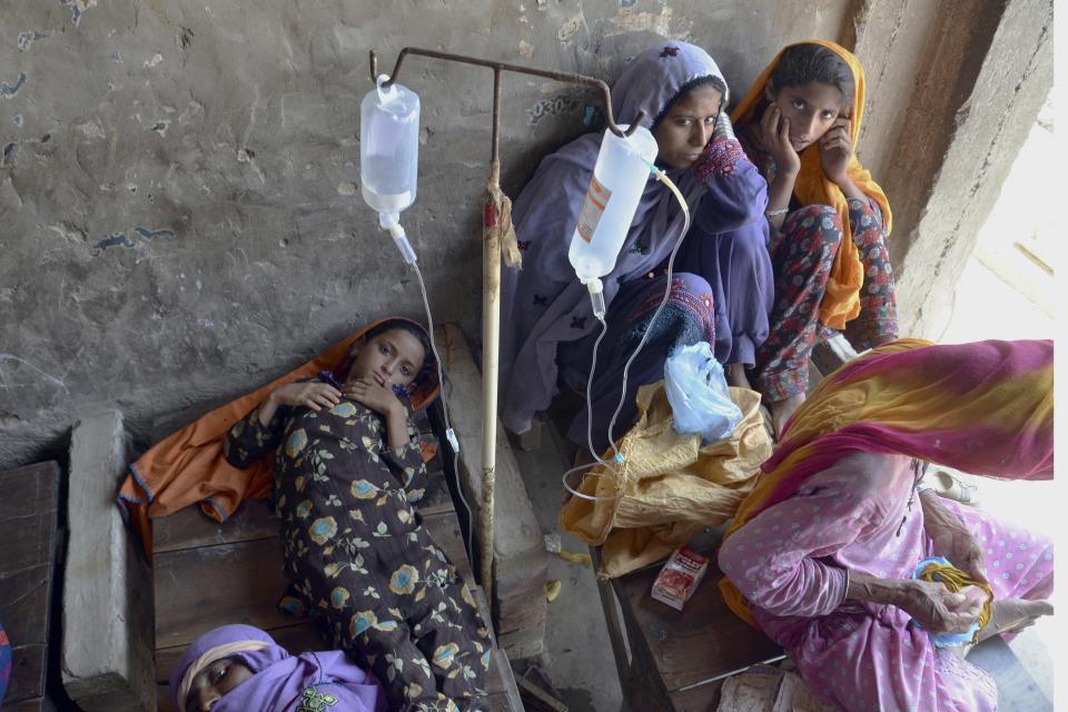 A sick girl and women receive treatment at a temporary medical center setup in an abandoned building, in Jaffarabad, a flood-hit district of Baluchistan province, Pakistan, Thursday, Sept. 15, 2022. The devastating floods affected over 33 million people and displaced over half a million people who are still living in tents and make-shift homes. The water has destroyed 70% of wheat, cotton and other crops in Pakistan. (AP Photo/Zahid Hussain)