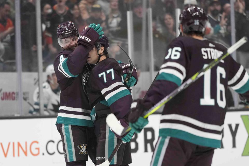 Anaheim Ducks' Frank Vatrano (77) is hugged by Cam Fowler (4) after scoring a goal, his second goal of the night, during the first period of an NHL hockey game against the San Jose Sharks, Sunday, Nov. 12, 2023, in Anaheim, Calif. (AP Photo/Jae C. Hong)