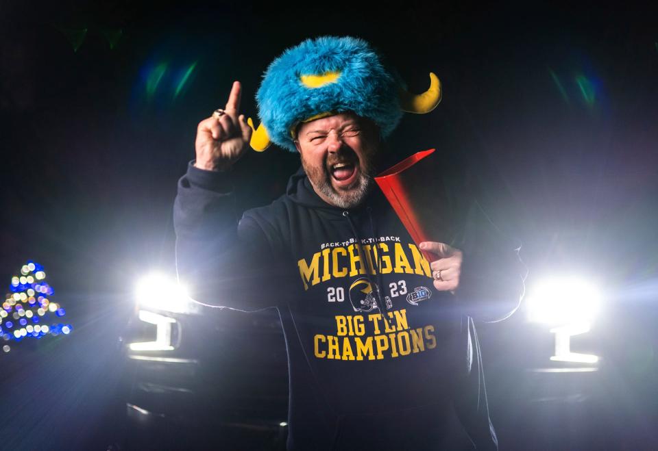 Jeff Holzhausen, of Chelsea, poses wearing his blue and yellow water buffalo hat that he wears to games as a super fan before leaving his home early morning on Friday, Jan. 5, 2024, to drive to Houston with his children to see the University of Michigan football team's championship game against Washington.