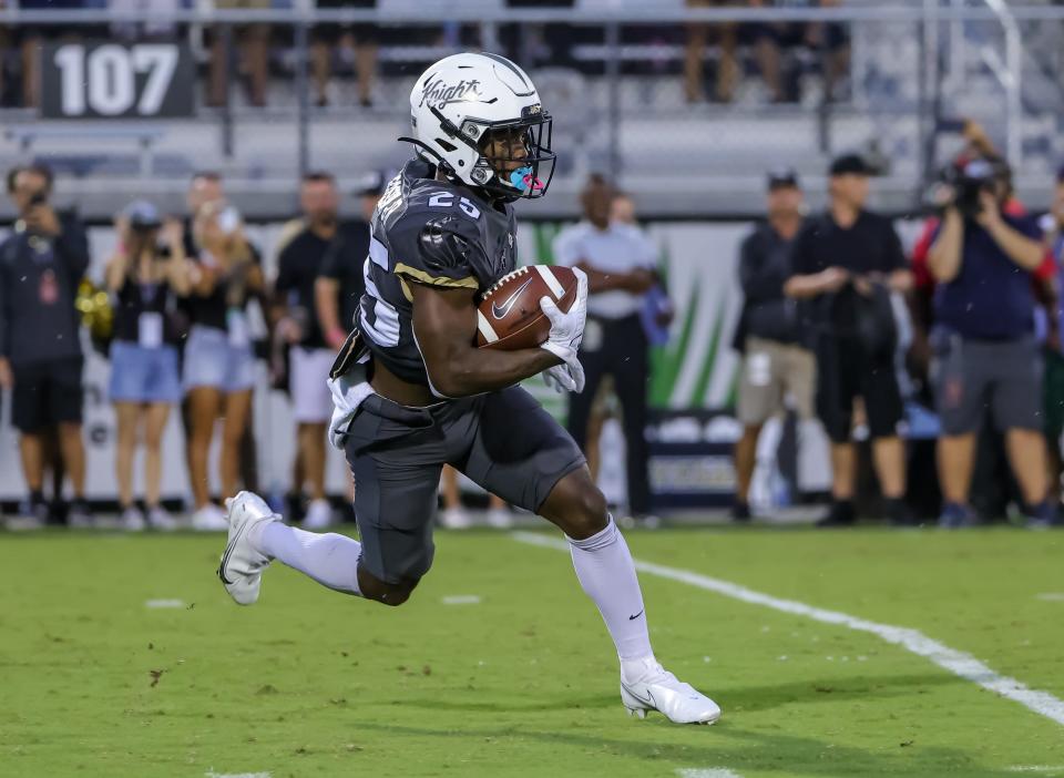 Sep 11, 2021; Orlando, Florida, USA; UCF Knights defensive back William Wells (25) runs the ball against the Bethune Cookman Wildcats during the first quarter at Bounce House. Mandatory Credit: Mike Watters-USA TODAY Sports