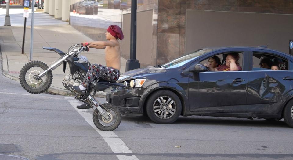 A stunt driver pulls a wheelie on Front Street in Downtown about noon on July 1, 2024. Ohio lawmakers voted recently to increase penalties for people found guilty of stunt driving.