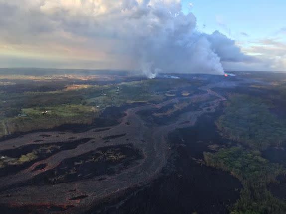 Lava from fissure 8 headed down toward Kahoho Bay. Orange, fountaining lava can be seen in the distance.