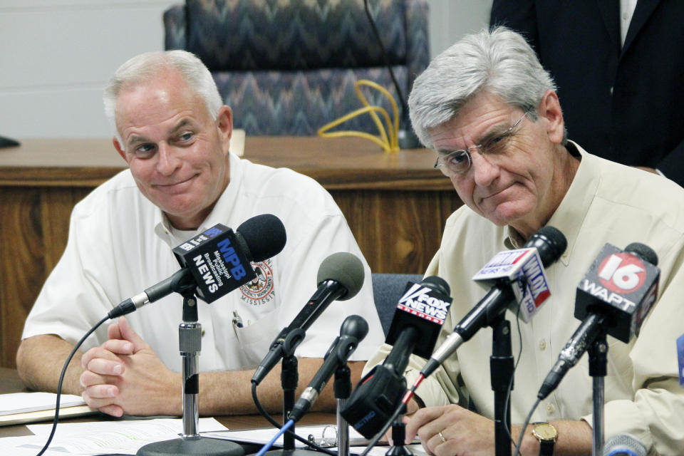 Harrison County Emergency Management Agency Director Rupert Lacy, left, listens as Gov. Phil Bryant discusses Gulf Coast preparations for Tropical Storm Isaac during a news conference at the Harrison County Emergency Operations Center in Gulfport, Miss., Monday, Aug. 27, 2012. (AP Photo/Rogelio V. Solis)