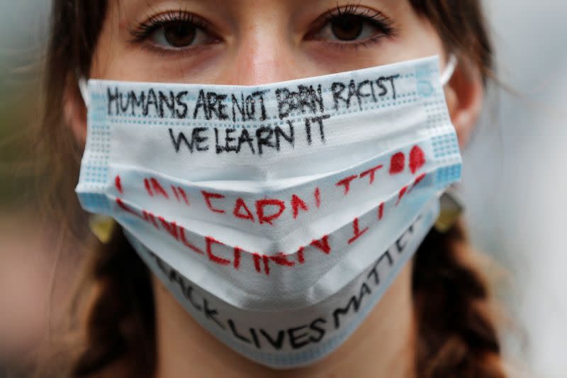 Elly Hawkins wearing a face mask bearing slogans poses to a camera during a Black Lives Matter protest following the death in Minneapolis police custody of George Floyd, in Tokyo