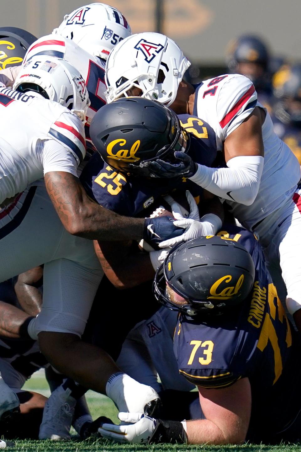 Arizona safeties Christian Young (5) and Isaiah Taylor (18) tackle California running back DeCarlos Brooks (25) during the first half of an NCAA college football game in Berkeley, Calif., Saturday, Sept. 24, 2022. (AP Photo/Godofredo A. VÃ¡squez)