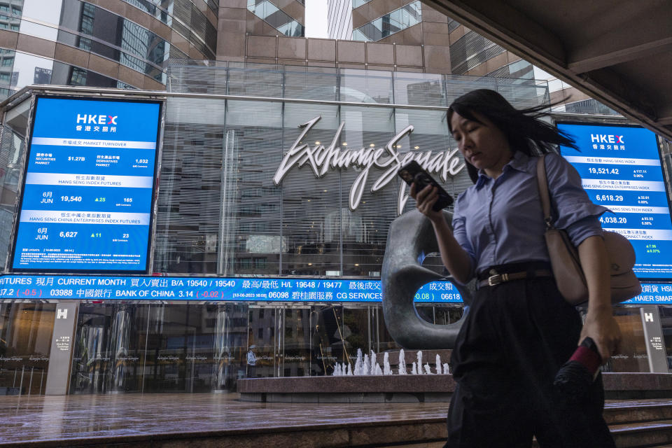 A pedestrian passes by the Hong Kong Stock Exchange electronic screen in Hong Kong, Wednesday, June 14, 2023. Asian stock markets followed Wall Street higher on Wednesday after a cooler reading on U.S. inflation fueled hopes the Federal Reserve will postpone a possible interest rate hike. (AP Photo/Louise Delmotte)