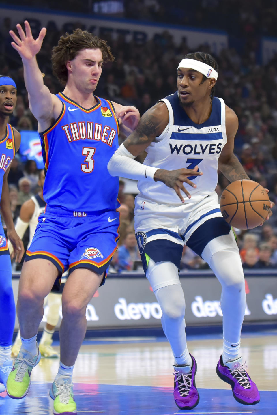 Minnesota Timberwolves forward Jaden McDaniels, right, pushes past Oklahoma City Thunder guard Josh Giddey during the first half of an NBA basketball game Tuesday, Dec. 26, 2023, in Oklahoma City. (AP Photo/Kyle Phillips)