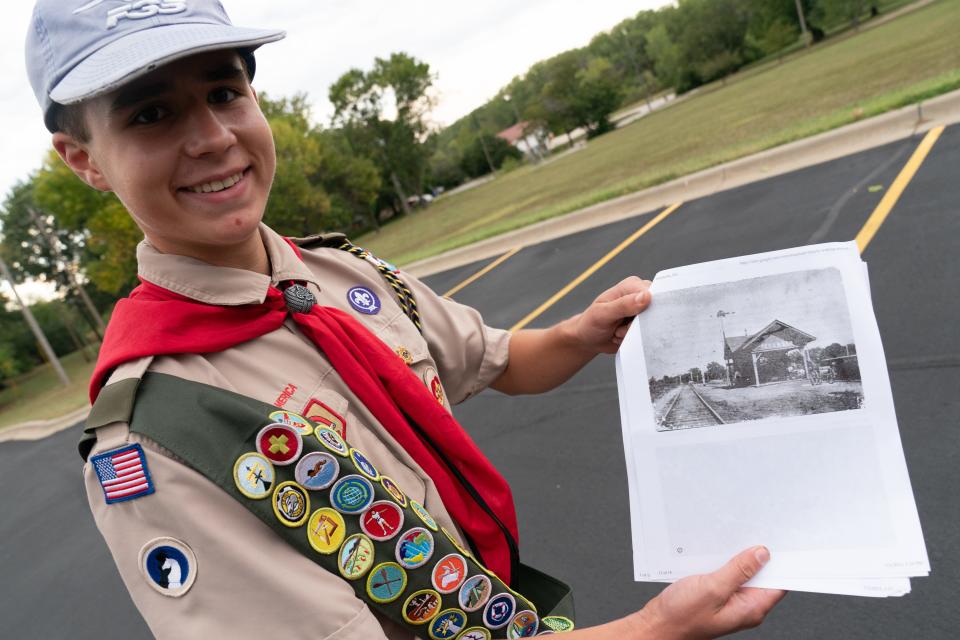 Carter Vincent shows off an old photograph of the Tecumseh rail depot. Vincent, who created a 3-mile walking tour of the town for his Eagle Scout project, will formally receive that rank at a ceremony in November.