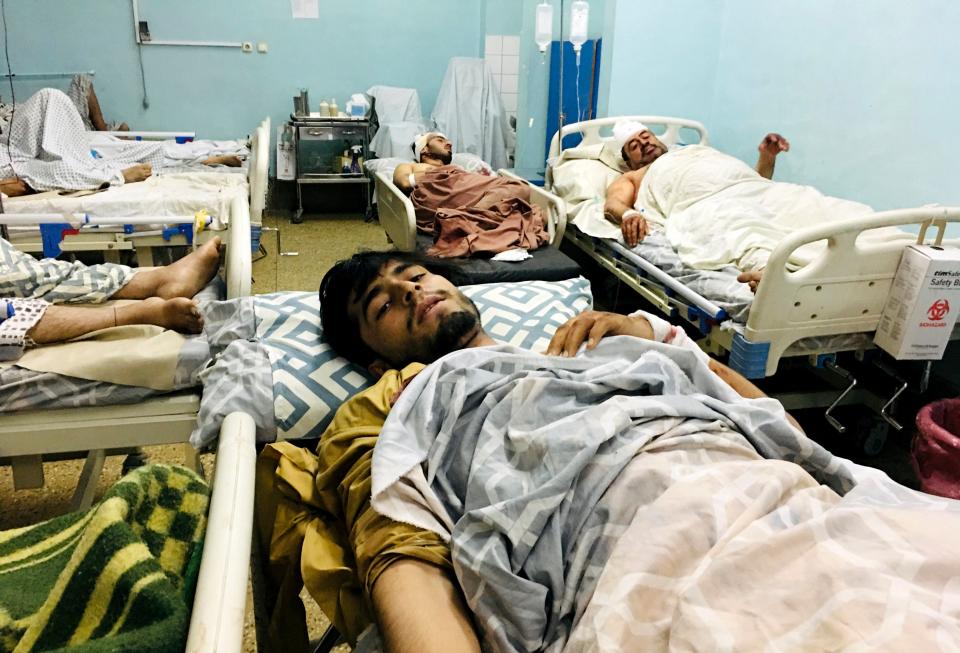 Wounded Afghans lie on a bed at a hospital after the deadly explosions (AP)