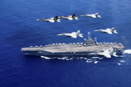 FILE PHOTO: A combined formation of aircraft from Carrier Air Wing (CVW) 5 and Carrier Air Wing (CVW) 9 pass in formation above the Nimitz-class aircraft carrier USS John C. Stennis (CVN 74) in the Philippine Sea on June 18, 2016.     Courtesy Steve Smith/U.S. Navy/Handout via REUTERS