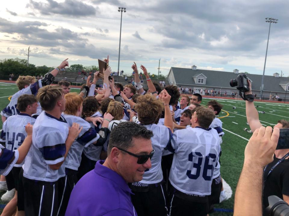 Rumson-Fair Haven's Vice Principal of athletics and student activities Chris Lanzalotto (center) just handed off the trophy to the players after they defeated Summit, 9-5. Rumson-Fair Haven defeats Summit in the NJSIAA Group 2 State Final on June 3, 2022 at Rumson-Fair Haven Regional High School