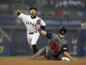 United States' Buster Posey is safe at second as Japan's Ryosuke Kikuchi throws to first during the third inning of a semifinal in the World Baseball Classic in Los Angeles, Tuesday, March 21, 2017. (AP Photo/Chris Carlson)