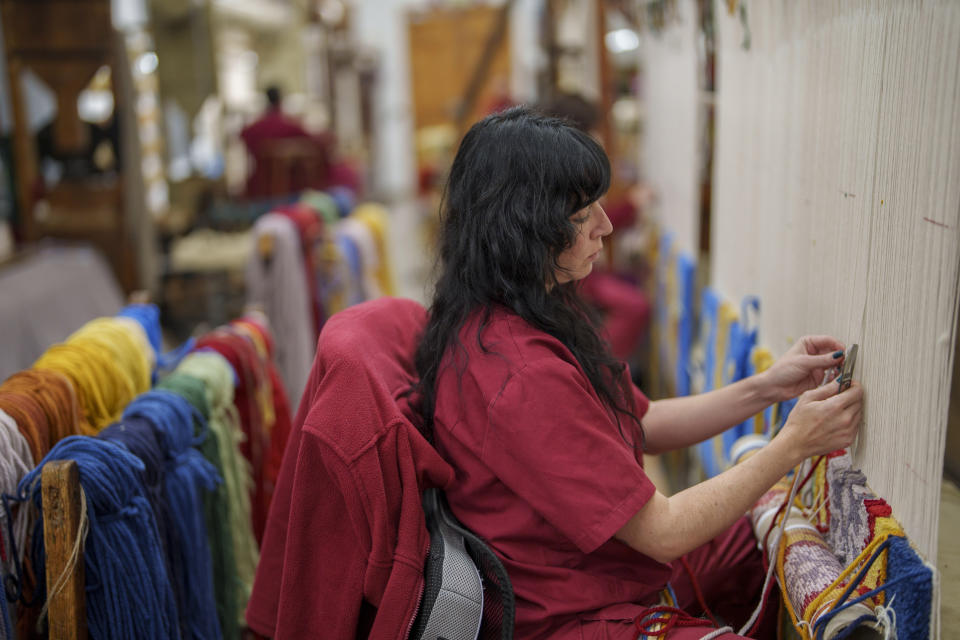 A craftswoman weaves a tapestry at the Royal Tapestry Factory in Madrid, Spain, Friday, Nov. 30, 2023. Since its foundation in 1721, the Royal Tapestry Factory of Madrid has not stopped producing. It was Philip V, then King of Spain, who had the factory built with the help of Catholic craftsmen from Flanders to replace the lack of private initiative that existed at the time. (AP Photo/Manu Fernandez)